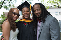 Photo of a graduate with parents. 