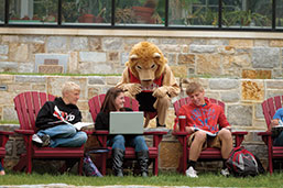 Photo of mascot with students. Link to What to Give